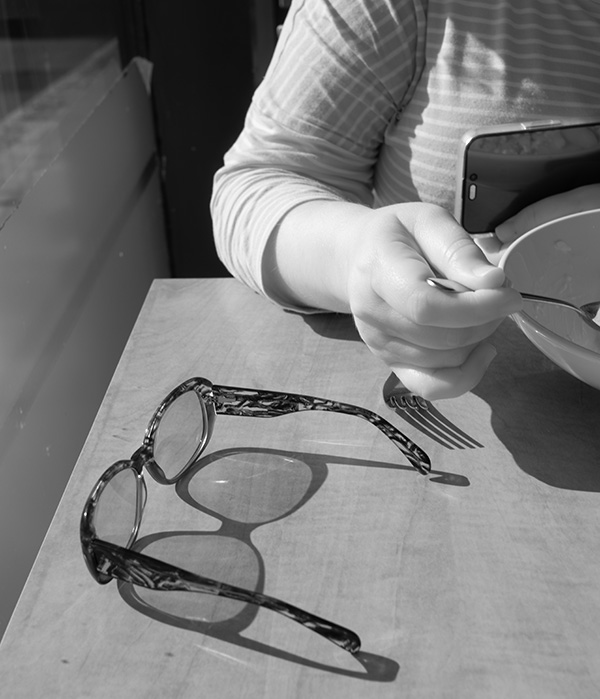 Infrared Photo of Glasses, Hand, Bowl, and Cellphone.